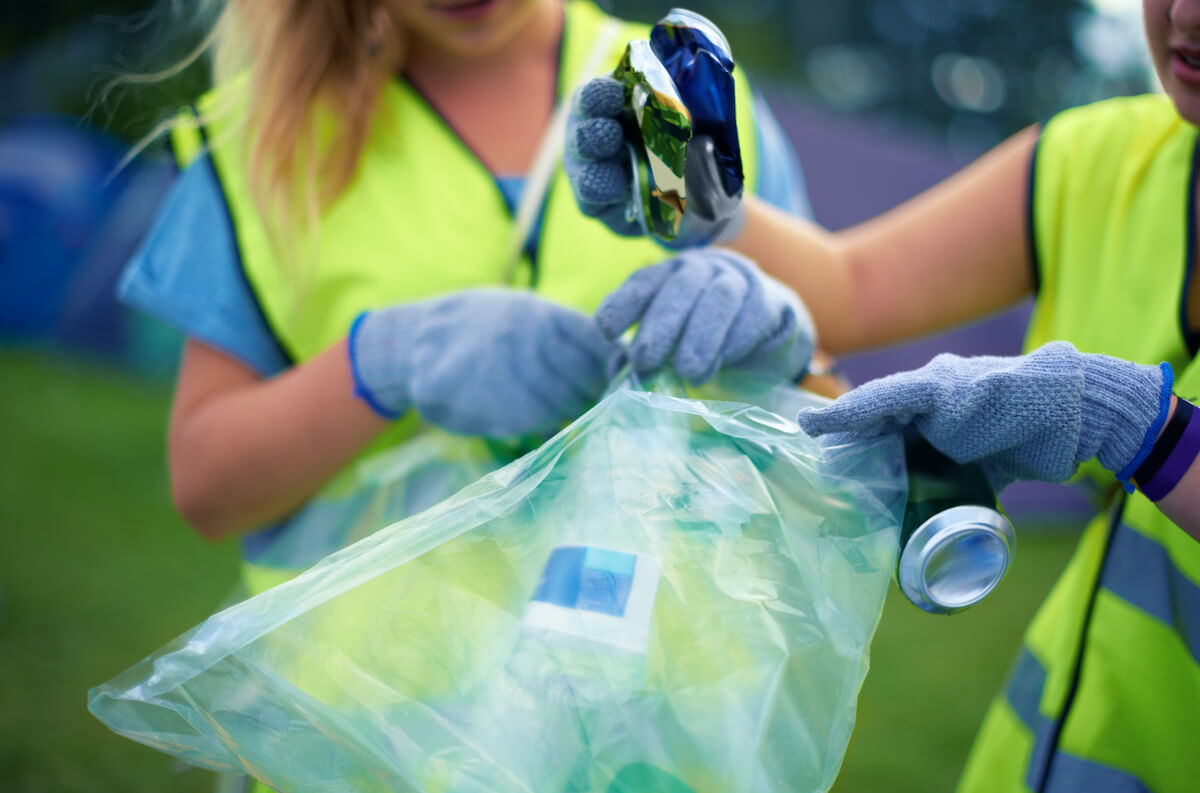 Two young women picking up trash as they might do through alternative sentencing